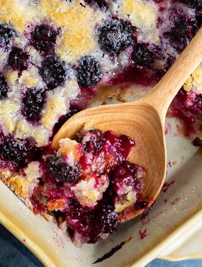 Close-up of a spoonful of juicy blackberry cobbler, illustrating the texture applicable to peach cobbler.