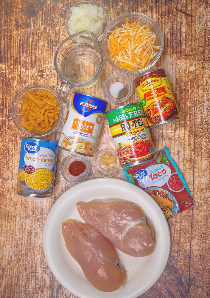 Ingredient layflat of chicken breasts, onion, garlic, chicken broth, water, corn, diced tomatoes and green chilies, enchilada sauce, taco seasoning, chili powder, showcasing the fresh and flavorful components