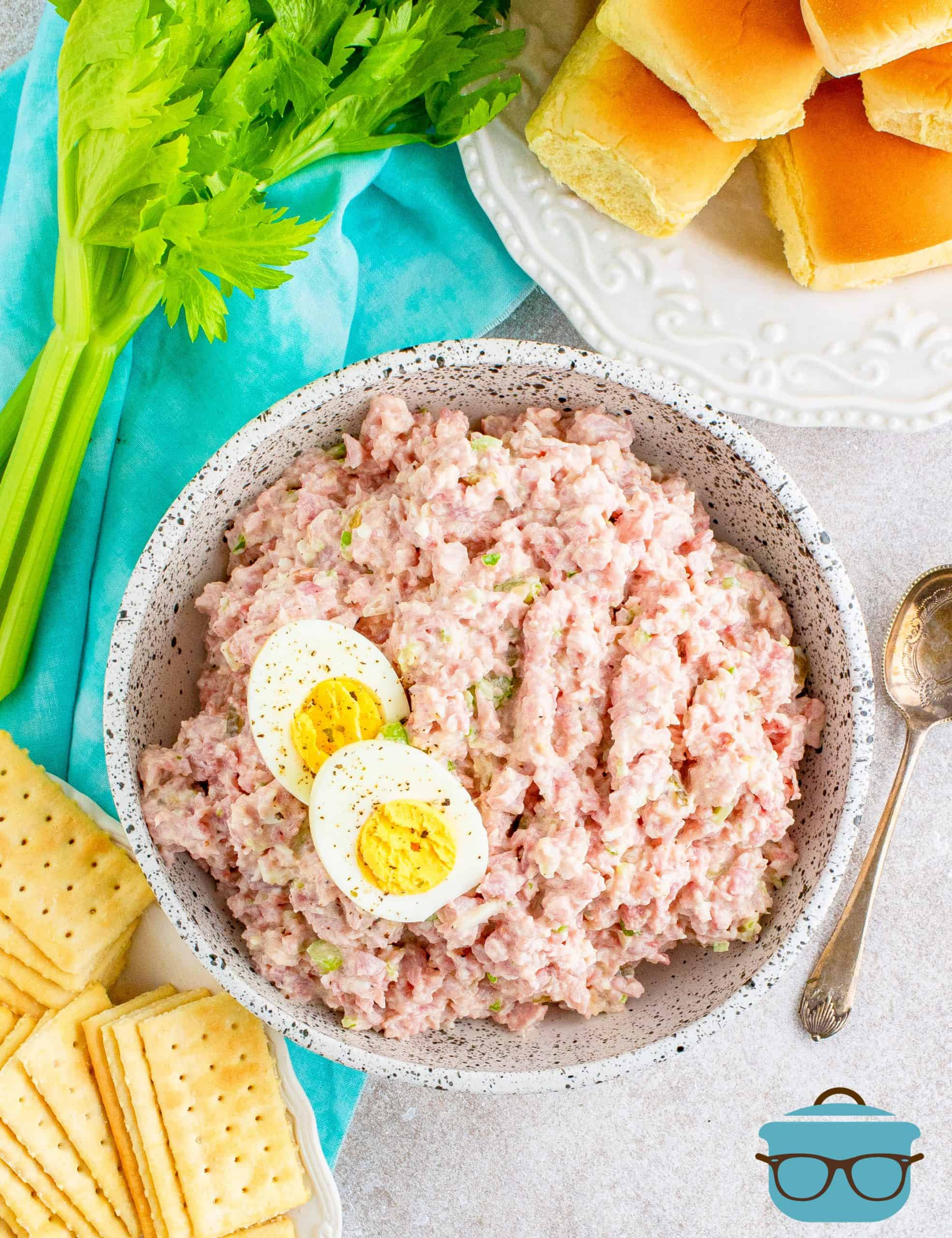 overhead shot of ham salad in a bowl with rolls and crackers off to the side