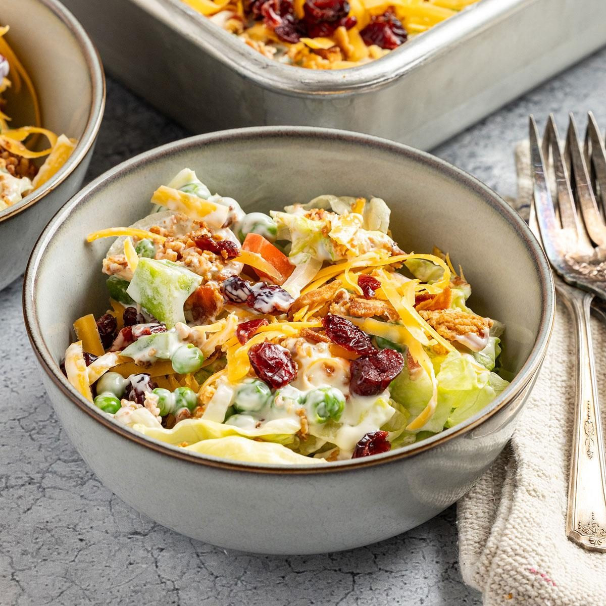 Layered Salad, a colorful overnight salad in a glass bowl, showing distinct layers of ingredients.