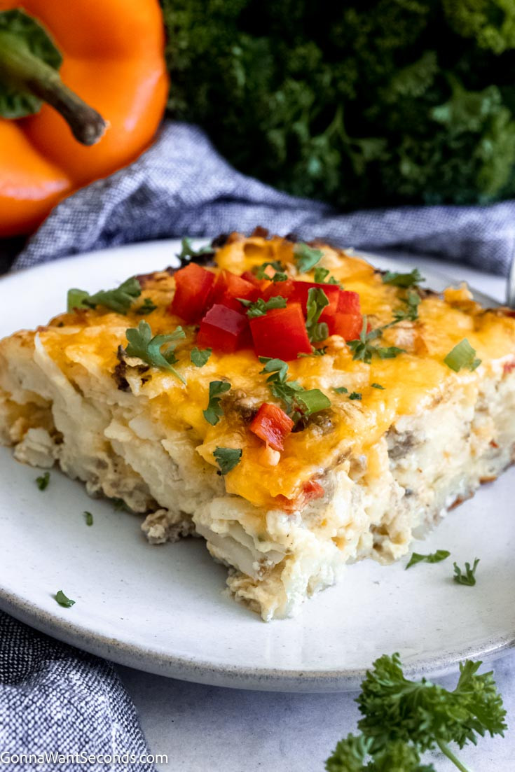 Slice of pioneer woman hashbrown breakfast casserole showcasing layers of hash browns, sausage, and cheese