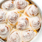 Close up of a pan of frosted cinnamon rolls