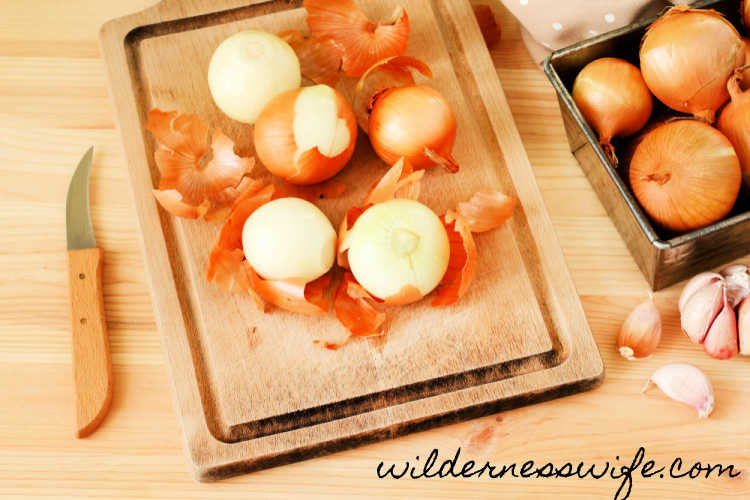 Close-up of sliced yellow onions on a wooden cutting board, showcasing their fresh and vibrant color.