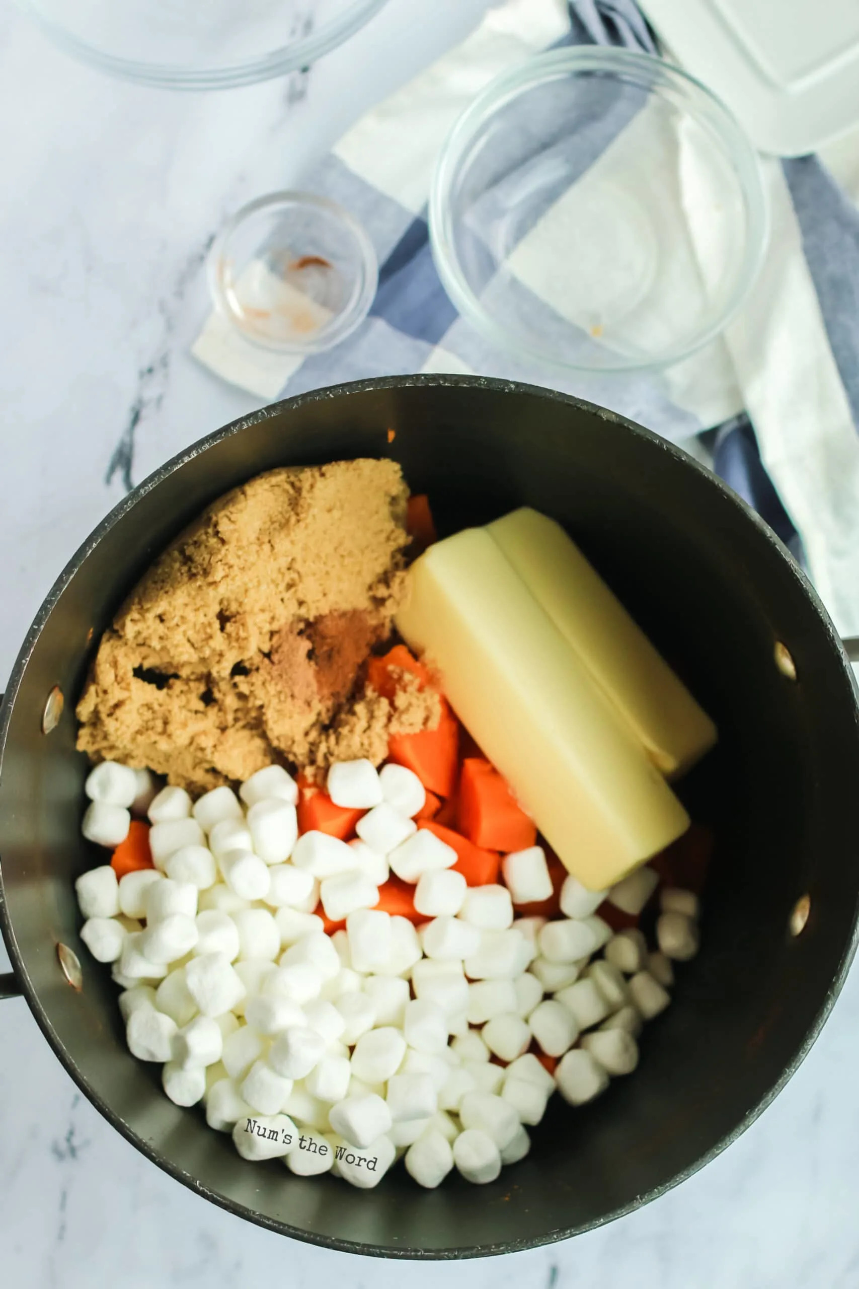 Adding brown sugar, butter, and miniature marshmallows to mashed sweet potatoes for Pioneer Woman Sweet Potato Casserole