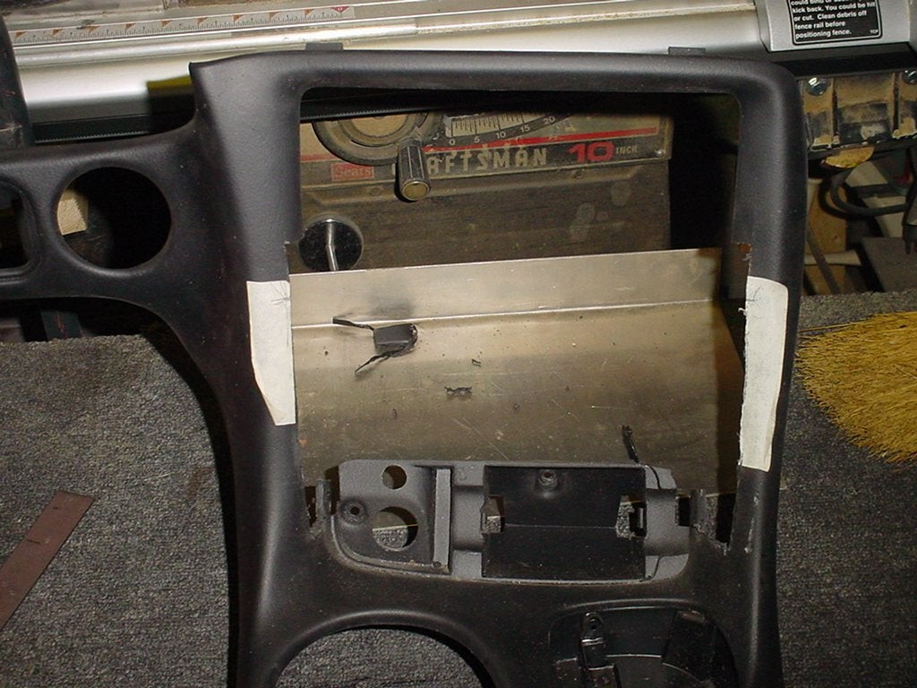 Modified Corvette C5 console with sections cut out to accommodate a double DIN radio, showing console trimming for installation