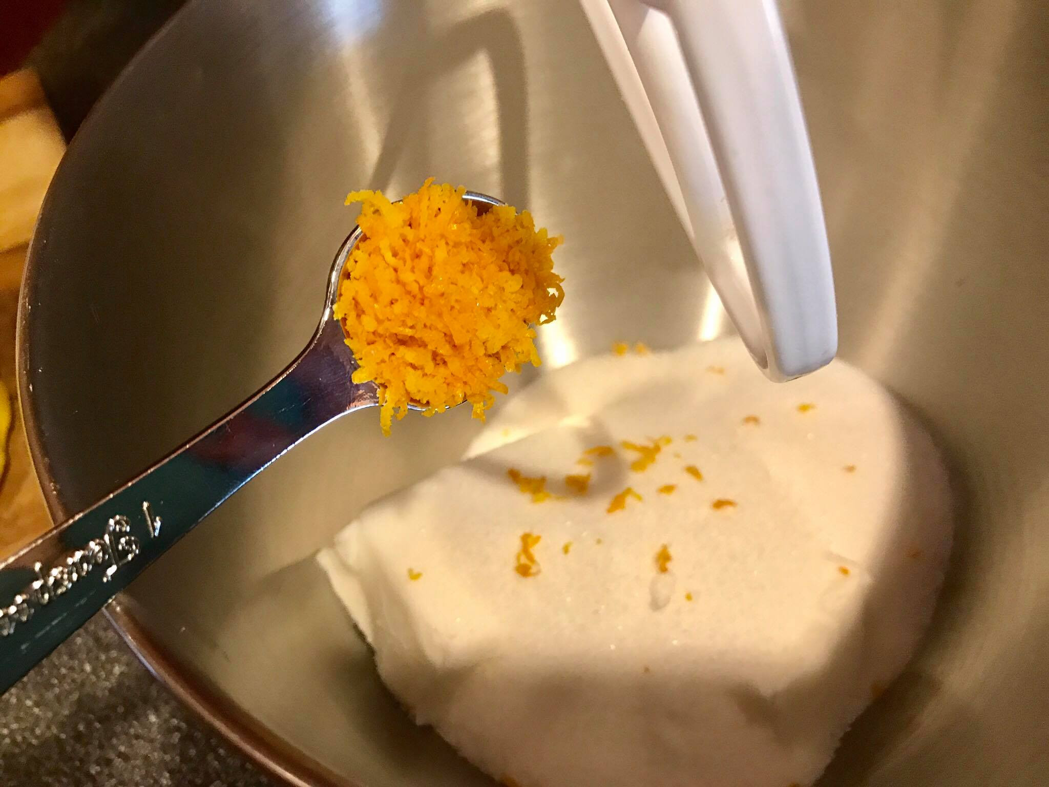 Adding orange zest to the sugar and shortening mixture in a mixer