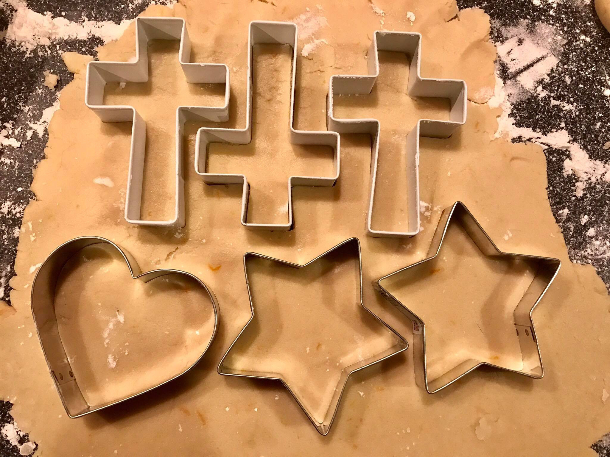 Cutting out sugar cookie shapes with cookie cutters