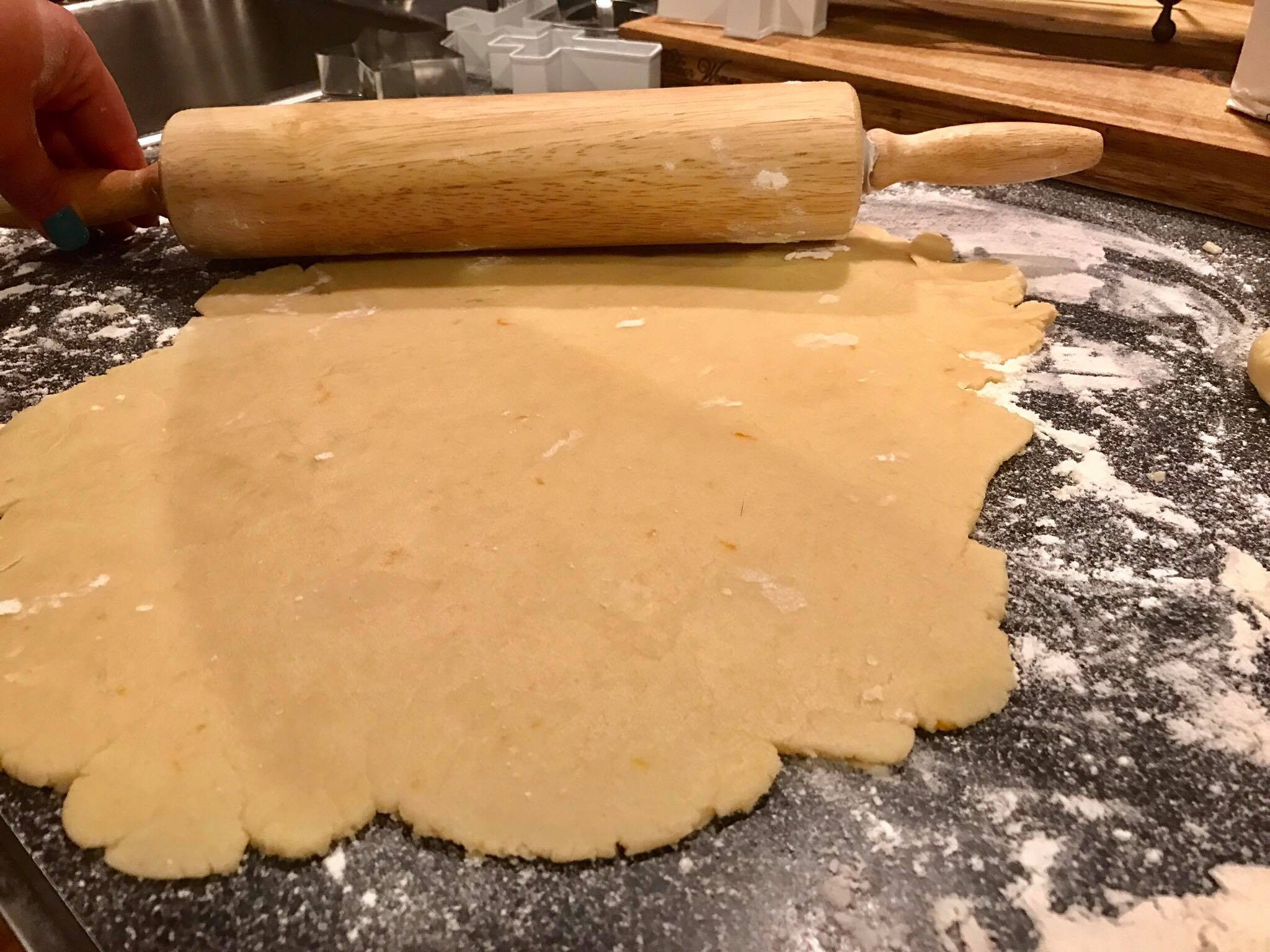 Rolling out chilled sugar cookie dough on a floured surface