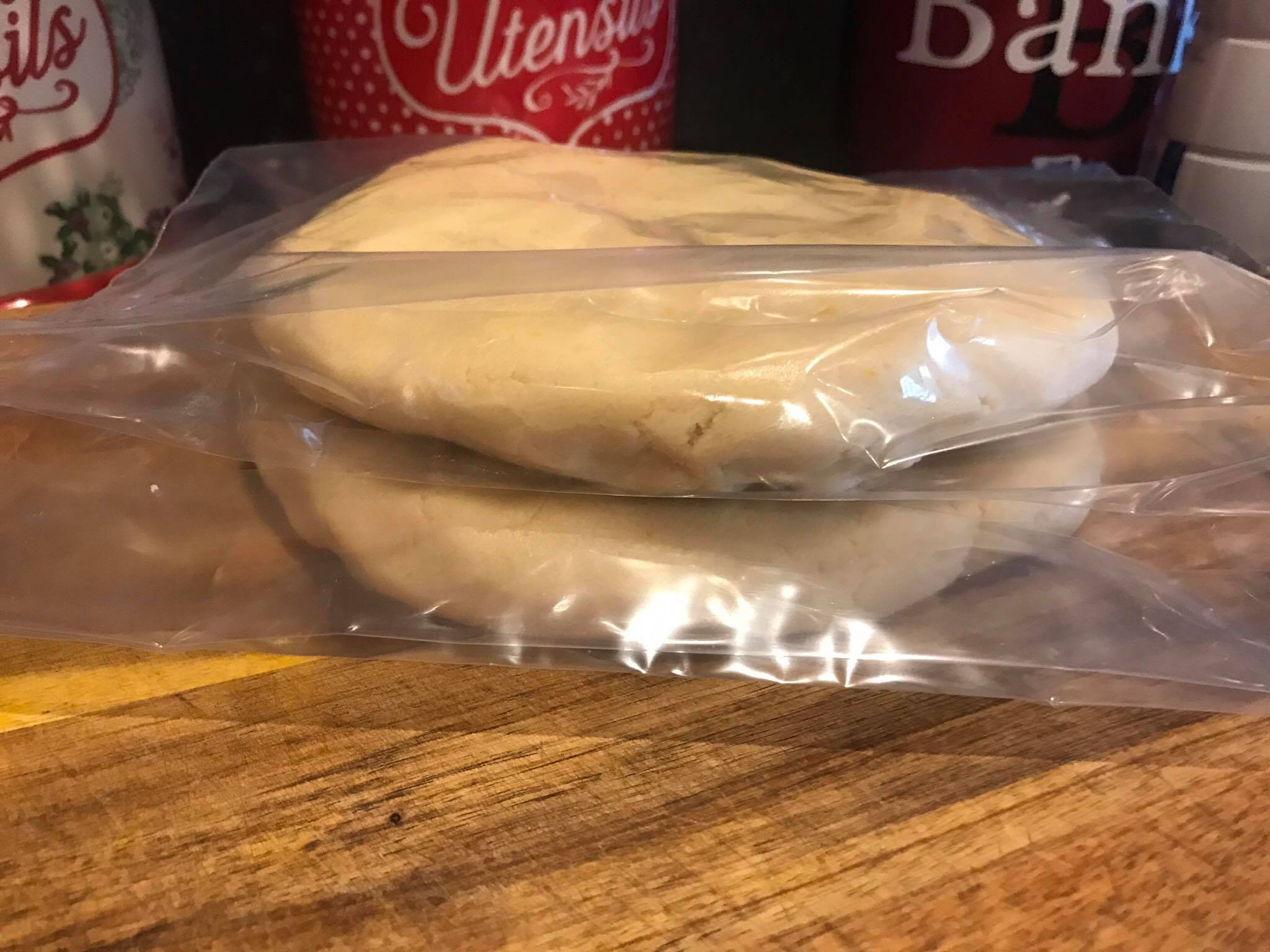 Chilled sugar cookie dough disks in plastic bags ready for refrigeration