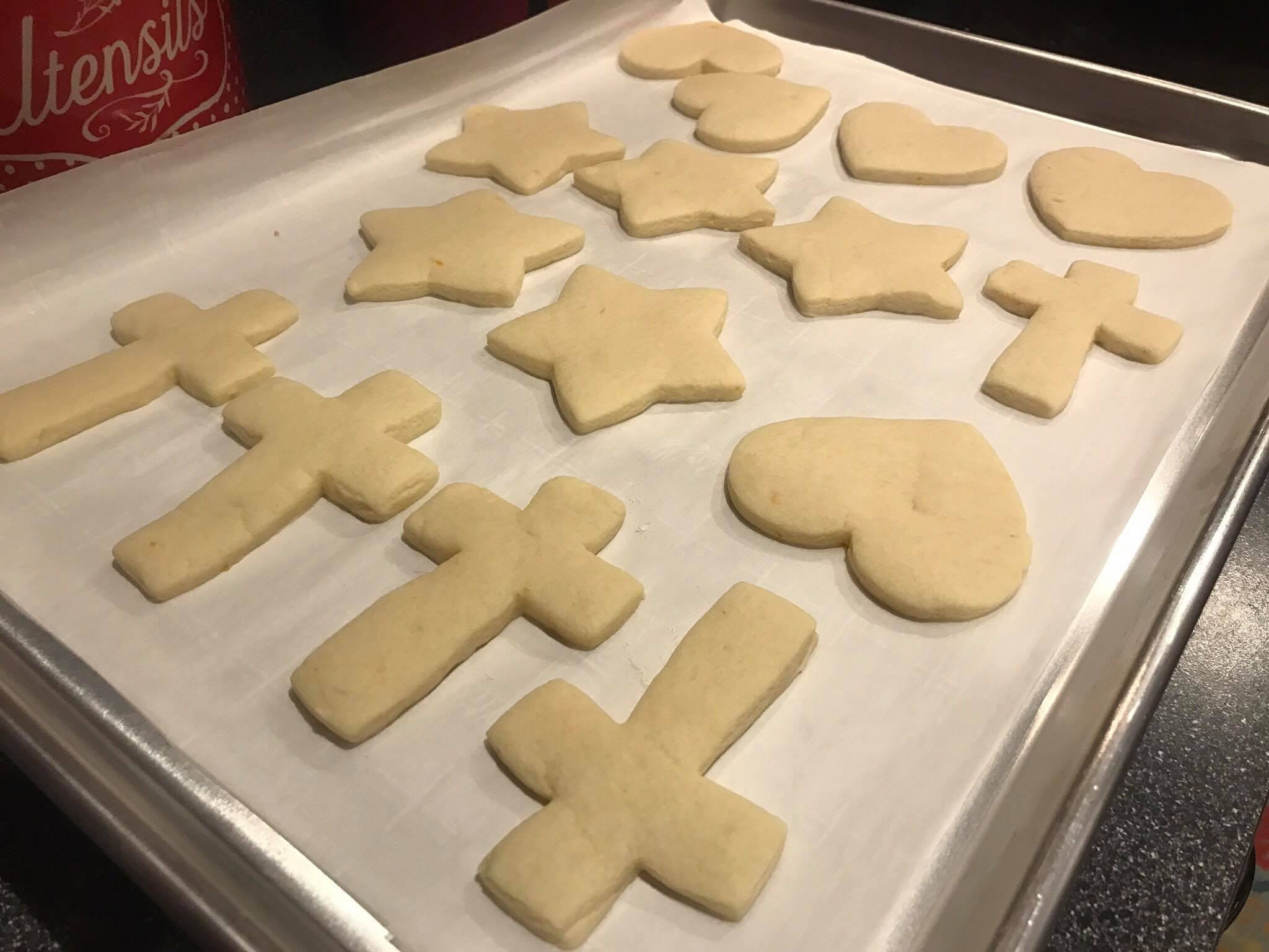 Baked sugar cookies cooling on a baking sheet