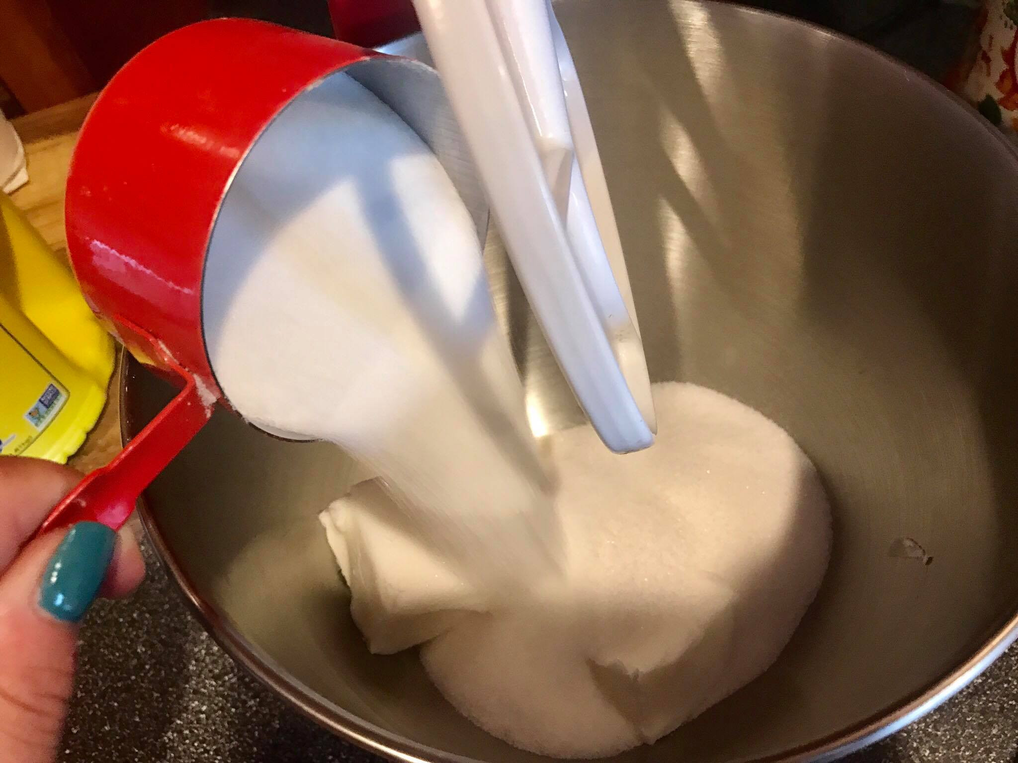 Mixing shortening and sugar in an electric mixer bowl