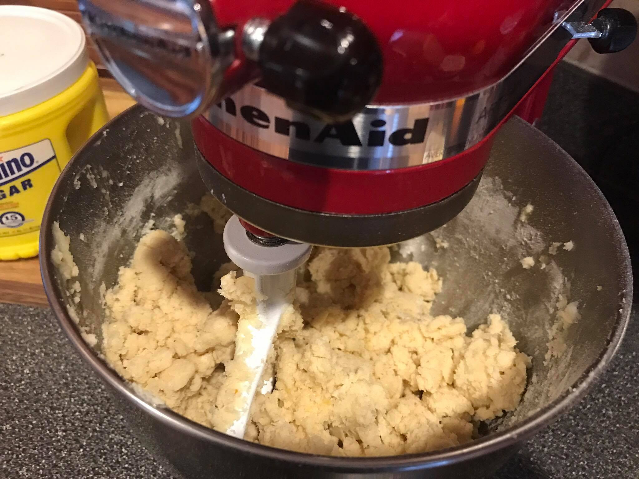 Pouring milk into the mixing bowl to complete the sugar cookie dough