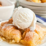 Overhead view of Mountain Dew Apple Dumplings on a white plate with vanilla ice cream, showcasing the golden-brown crust and syrupy sauce, a testament to Pioneer Woman's inspired recipe.