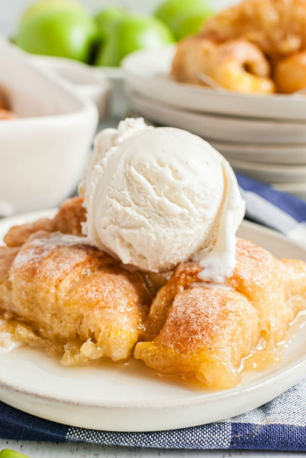 Overhead view of Mountain Dew Apple Dumplings on a white plate with vanilla ice cream, showcasing the golden-brown crust and syrupy sauce, a testament to Pioneer Woman's inspired recipe.