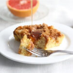 Overnight french toast casserole with syrup being drizzled, showcasing its golden-brown crust and soft interior