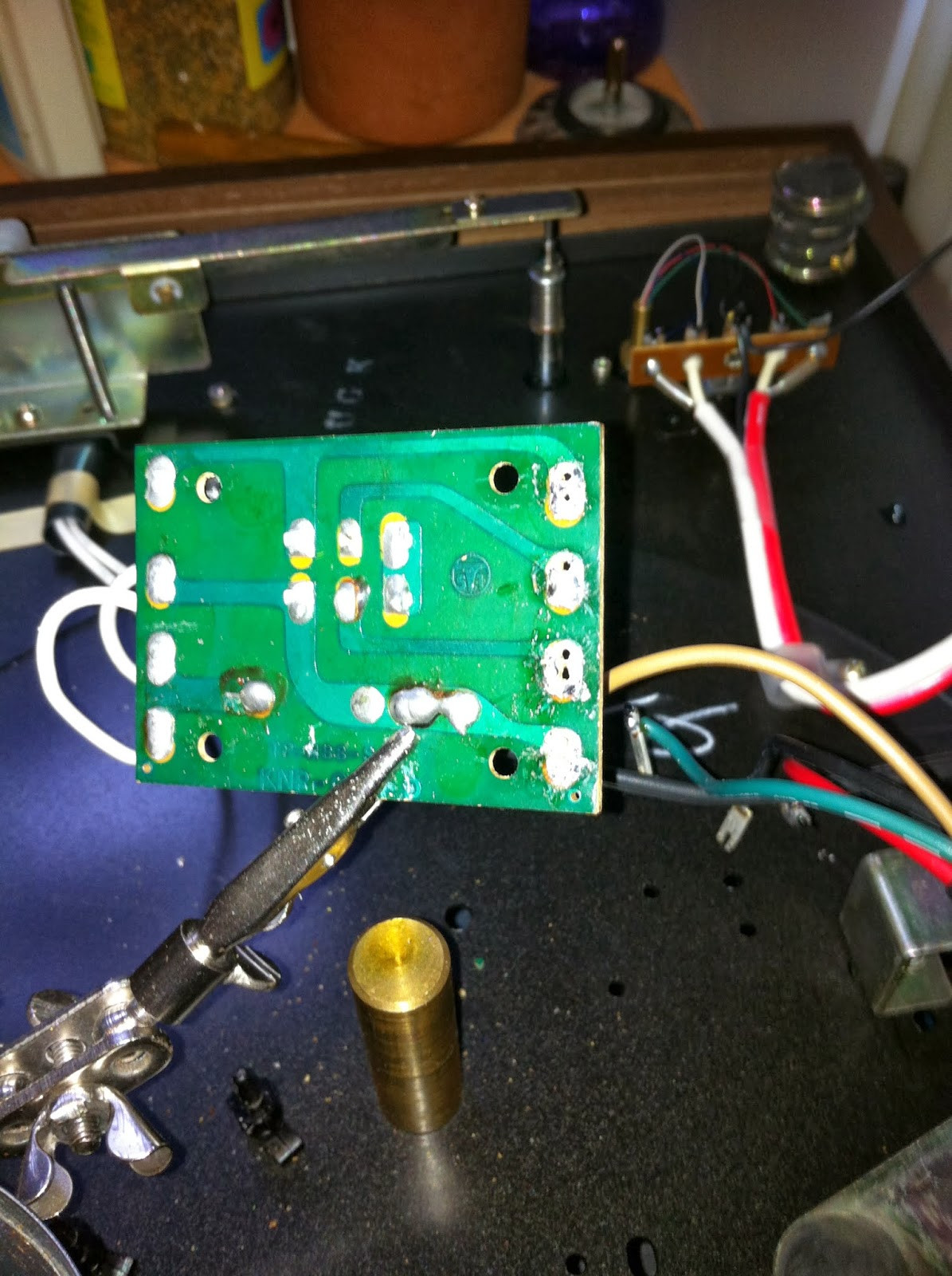 Desoldering Pioneer PL-12D motor wire tabs from the circuit board using a desoldering pump.