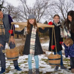 A family enjoying Maple Days event at Pioneer Creek Village